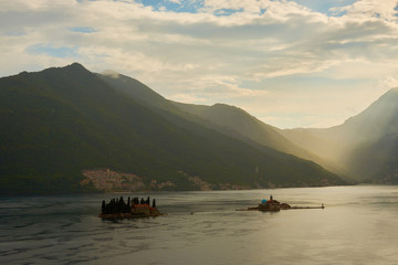 an island in the middle of the Adriatic Sea against the backdrop of mountains after rain with cumulus clouds on the sky.