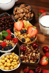 Cereal. Bowls of various cereals, berries and milk for breakfast. Muesli with kids cereals.