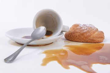 Roll of golden puff pastry and a cup of spilled coffee