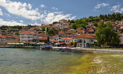 Fototapeta na wymiar Ochrid, Macedonia: toursit walking and enjoing in the view of old part of Ochrid city on a boat dock on a Ochrid lake