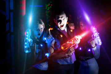 Fototapeta na wymiar Friends with laser guns in colored beams