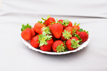 Fresh strawberries on a white plate.