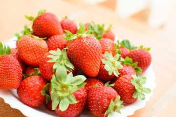 Fresh strawberries on a white plate.