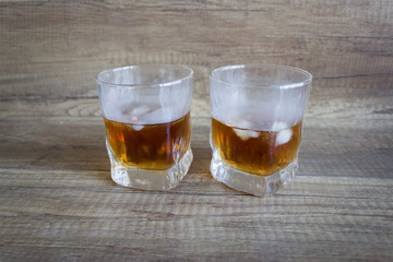 Whiskey. Glass of whiskey with ice, bourbon on a wooden background. Scotch in a glass. Alcoholic...