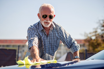 Senior man cleaning his car