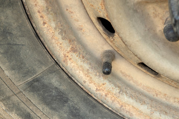 Tire valve cap at old steel wheel and old tire.