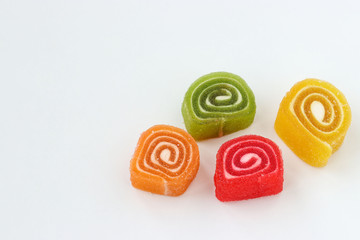 Multicolored marmalade is located on a white background, horizontal photo