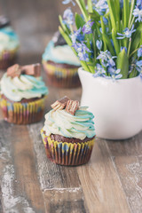 Handmade chocolate muffins with decorations. Book and a bouquet of Scilla