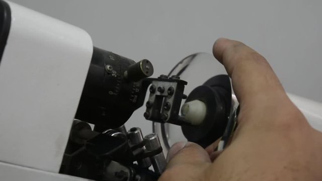 Close up shot of scientis looks through microscope for his experiments, in laboratory room, he hope this experiment to find experimental good results