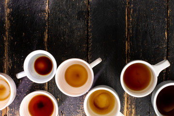 White cups with coffee residue on wooden table with space for text. Composition for coffee shop and...