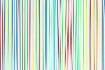 A lot of colored plastic straws or tubes with blue, red, yellow and green stripes. Abstract background.