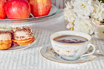 Still-life with a cup, cakes, apples, a bouquet of roses
