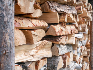 Firewood stacked in a woodpile close-up.