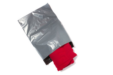 red jumper packed in gray mailing bag