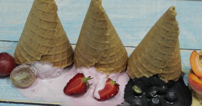 Sweet melted ice cream balls in a waffle cone. Different berries and fruits
