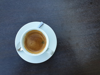 Coffee cream with foam on a dark stone table - top view