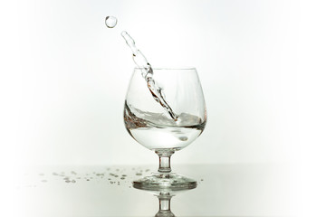 Water spray in wineglass. Water splash.