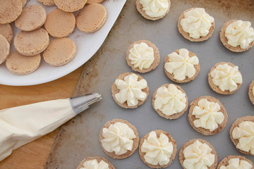 Cookies with Piped Frosting Delicate cinnamon cookies decorated with cream cheese frosting. Light and airy baking scene.