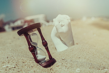 Hourglass and plaster hands on the sand. Concept of combining efforts to achieve goals.