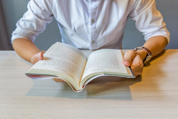 Close up of young man holding reading book