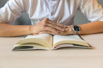 Close of man hands putting on book on table