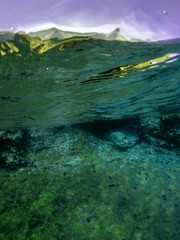 Underwater photo of tropical cave with emerald clear sea and coral reef