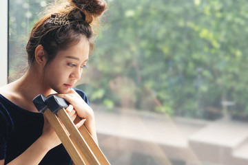 Young woman with broken leg at window