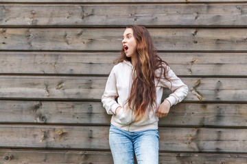 Happy girl smiling. Beauty portrait young happy positive laughing brunette woman on wooden wall background. European woman. Positive human emotion facial expression body language