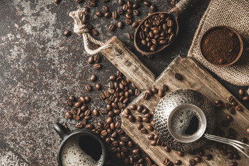Coffee on wooden board with coffee beans on dark textured background. Top view with copy space. Background with free text space.