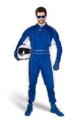 Race driver in blue white motorsport overall shoes gloves and safety gear crash helmet under his arm determined and ready to go isolated white background. Car racing motorcycle sport concept. - obrazy, fototapety, plakaty