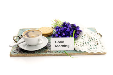 A cup with morning coffee and a bouquet of flowers
