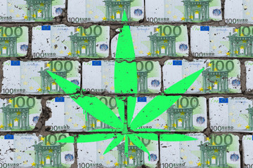 Painted cannabis leaf on wall of euro. Hemp business art concept.