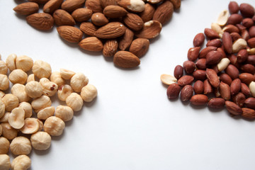 Hazelnuts, almonds and peanuts on white background closeup