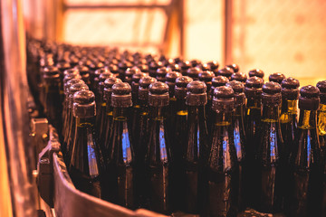View of glass bottles on the conveyor belt, bottle necks on the production line, brewery equipment,...