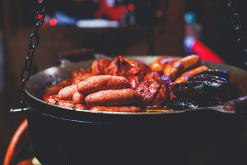 Variety assortment of different traditional european street food with sausages, mashed potatoes and stewed cabbage at one of the stalls at the Christmas market, Town Hall Square of Tallinn, Estonia