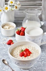 a healthy breakfast - raw oatmeal with milk and strawberries. Oatmeal is filled with milk at night and in the morning get porridge.