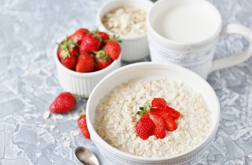 a healthy breakfast - raw oatmeal with milk and strawberries. Oatmeal is filled with milk at night and in the morning get porridge.