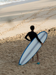 Beautiful beach Dreamland Bali lansdscape with surfer looking to the ocean