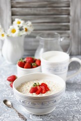 raw oatmeal with strawberries and milk. Oatmeal is filled with milk at night and in the morning get porridge.  healthy breakfast   