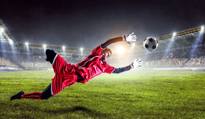 Fototapeta premium Soccer player on stadium in action. Mixed media