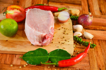 Fresh meat and spices are placed on the cutting board and wooden floors for cooking today