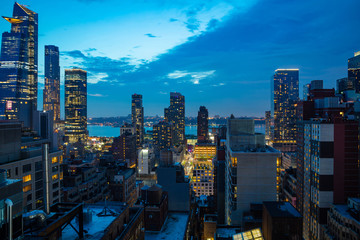 Aerial view of Manhattan skyscrapers lights, New York city, blue sky in the evening