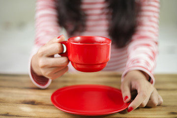Asian women wearing glasses are holding red coffee