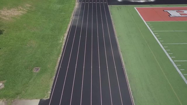 Drone flying over running track.