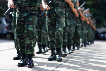 iron discipline of the best soldiers in army, a column of soldiers in uniform and with modern automatic weapons in hands of boots marching.