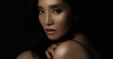 beautiful young woman closeup face and glossy skin under glamour low key concept