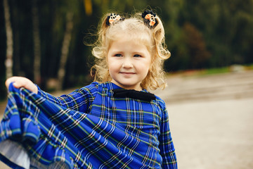 Cute little girl in a park. Child in a blue dress