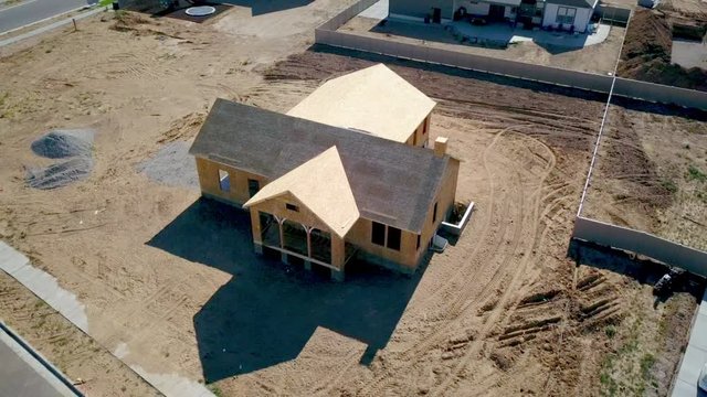 A drone shot floating around a newly built home with it’s walls and roof barely placed.