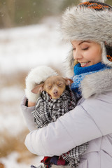 Woman hug warming her little dog in winter