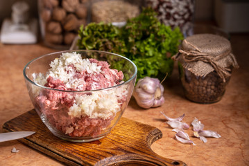 Minced meat with chopped onions in a glass plate.
